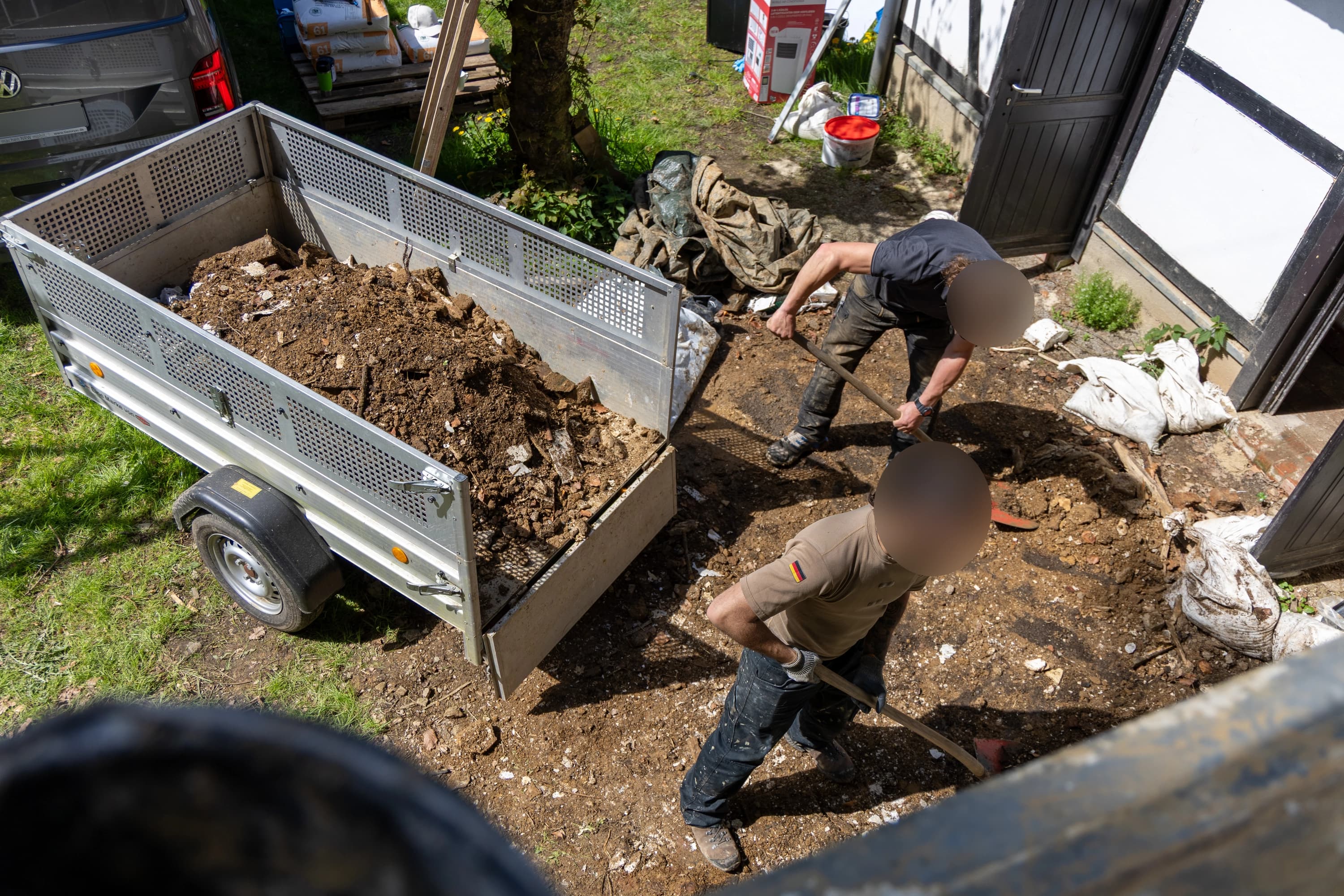 Schutt wird in den Hänger verladen.