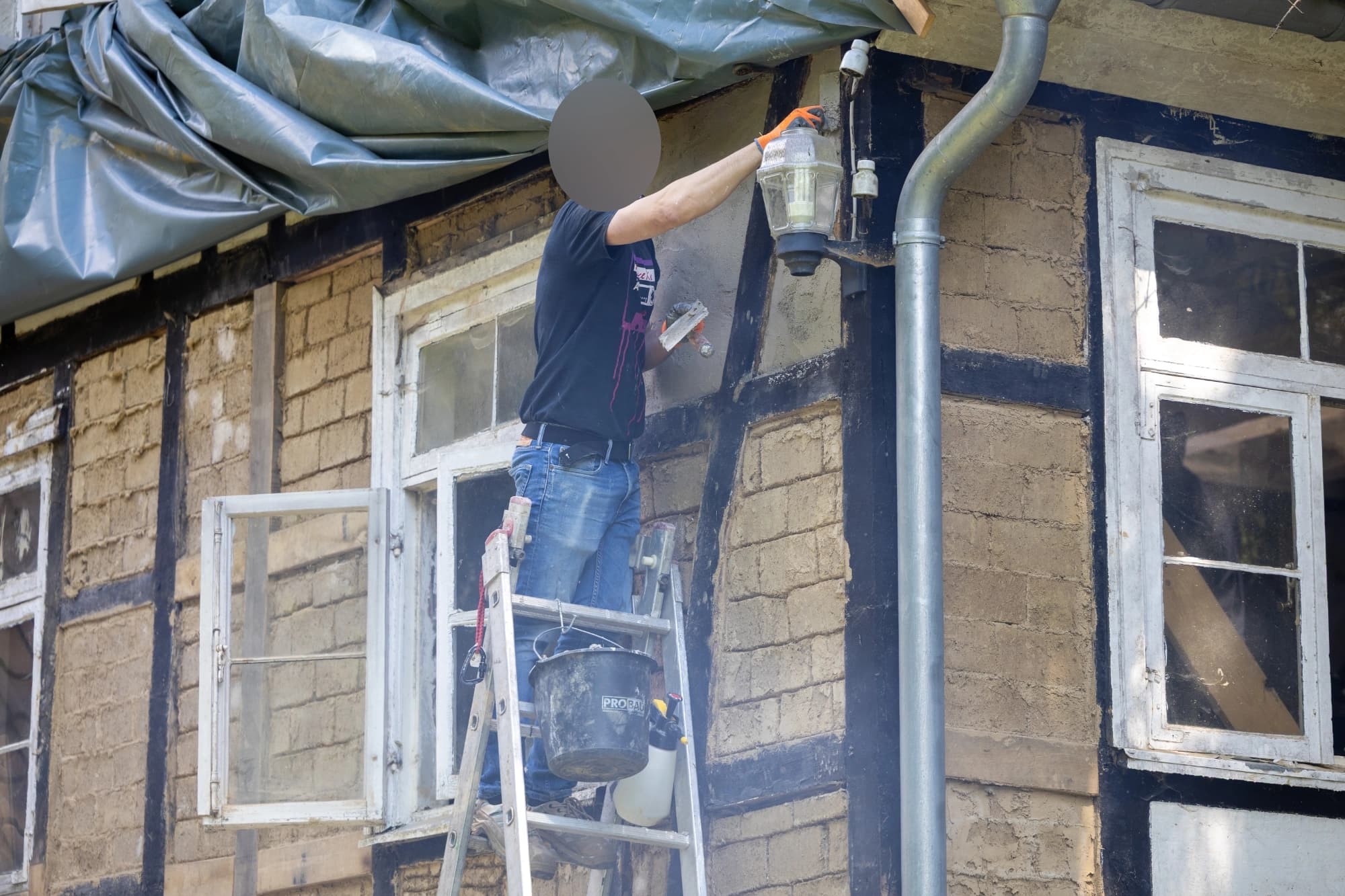 Die erste Putzschicht wird auf die Lehmsteine angebracht
