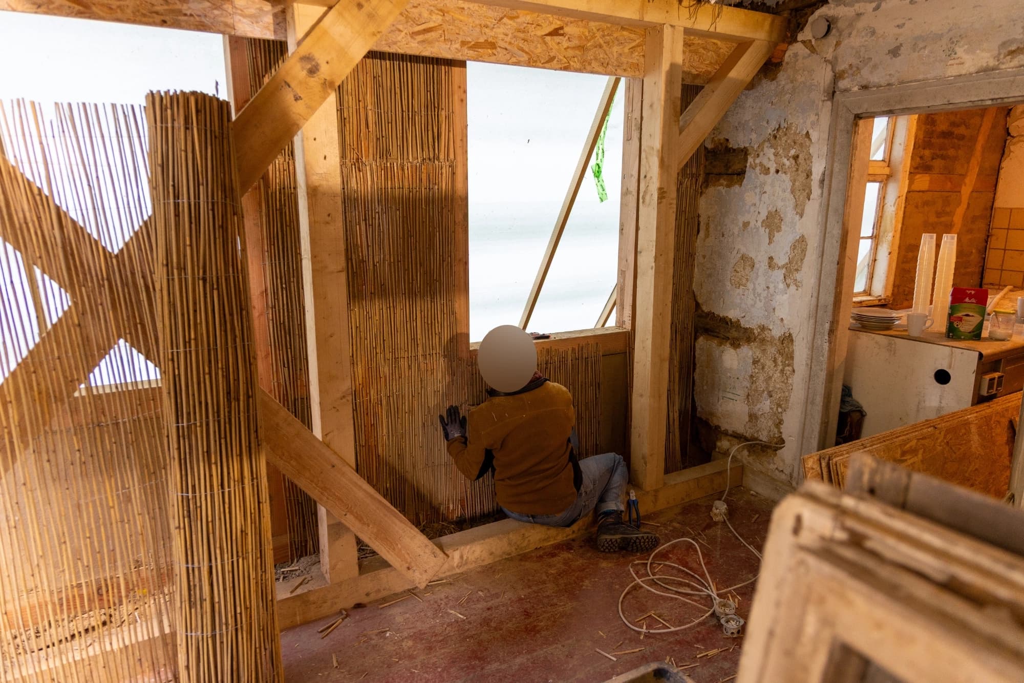 Strohmatten werden über die Wände gelegt.